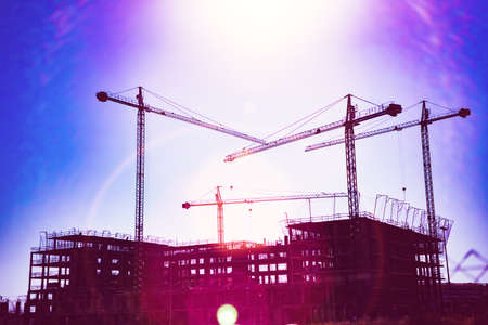 Sunset landscape and construction cranes and buildings.の写真素材