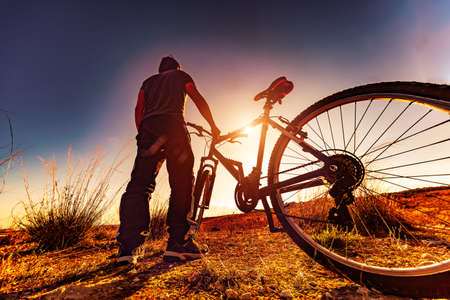 Biker and sunset landscape.leisure in outdoor with mountain bikeの写真素材