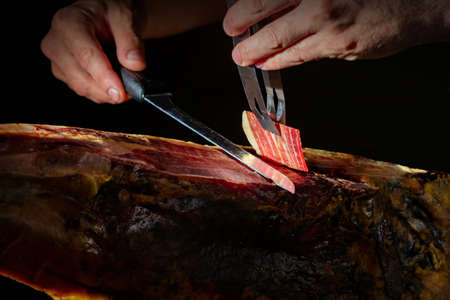 Slicing Spanish Ã­beric ham. Spanish jamon and traditional food.の写真素材