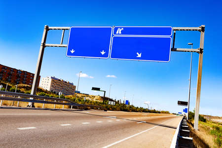 Empty road through city with blank road-signの写真素材