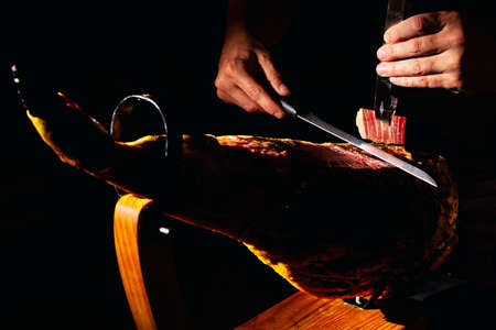 Close-up detail of master Iberian ham cutter on dark background.の写真素材