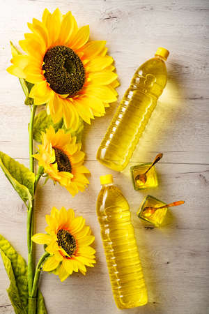 Plastic bottles with sunflower oil, fresh yellow sunflowers.Flat top view copy space.の写真素材