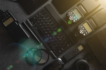 Digital photo workstation over black background. Top view of digital camera, flash, lens and laptop.の写真素材