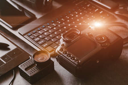 Digital photo workstation over black background. Top view of digital camera, flash, lens and laptop.の写真素材