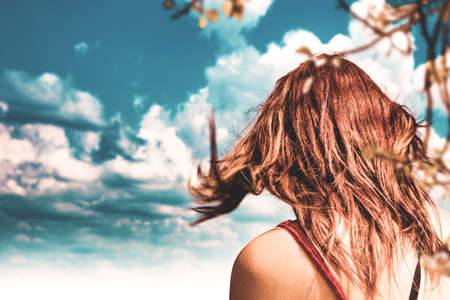 Romantic image of a young woman in the countryside with her hair blowing in the wind.の写真素材