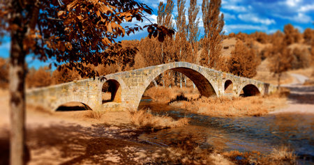 Beautiful old stone bridge in autumn forest at sunset. Ottoman architecture near the city of Teruel,Aragon,Spain.の写真素材