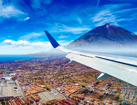 Aerial view of the sky over the mountains and the peak of the Teide volcano from the window of an airplane.の写真素材
