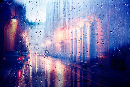 Abstract background of night city street raining through the windowの写真素材