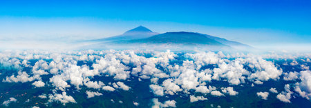 Aerial view of the sky over the mountains and the peak of the Teide volcano from the window of an airplane.の写真素材