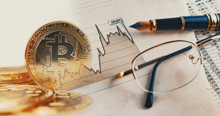 Bitcoin gold coin on finance and banking charts background.の写真素材
