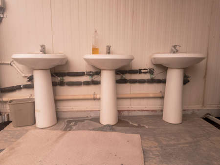 Three pedestal sinks along exterior wall of buildingの写真素材