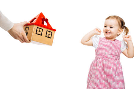 Happy toddler girl receiving a toy houseの写真素材