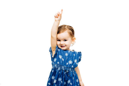 preschool toddler girl raising hand with index finger pointing upの写真素材