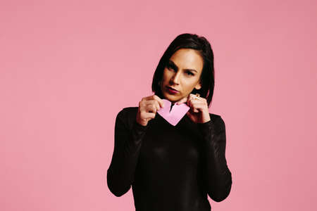 Woman ripping a heart, broken pink heartの写真素材