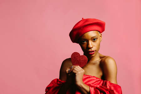 Sensual young woman in red holding a red heartの写真素材