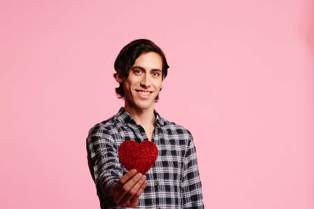 Sweet guy with big smile holding a red heart, be my Valentineの写真素材