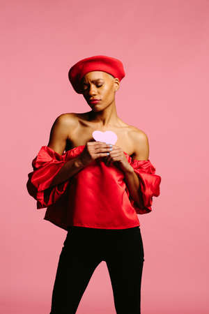 attractive young woman in red holding a pink heart, be my valentineの写真素材