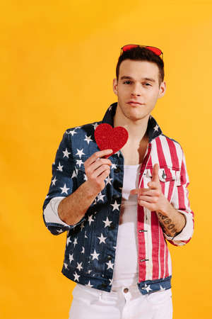 All-american cute guy holding a red heart in american flag jacketの写真素材
