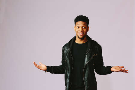Shocked young African American man smiling wearing a black jacketの写真素材