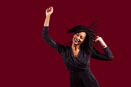 Woman with dreadlocks wearing a sparkly dress in celebrating, happy, funの写真素材