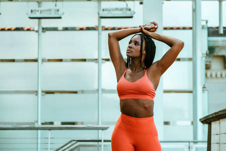 Beautiful young woman runner outdoor in sport outfit stretchingの写真素材