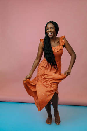 full length shot of young woman in long dress smiling and dancingの写真素材
