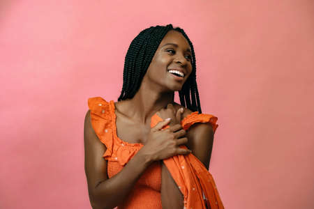 young black woman laughing and looking away while holding dress fabric in hands