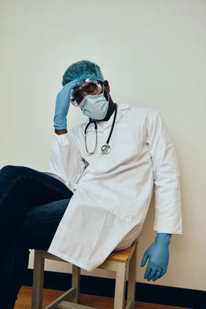 Exhausted Male Healthcare Worker Sitting On Chairの写真素材
