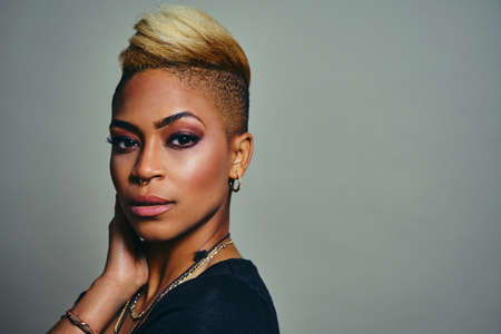 Portrait of a young cool woman wearing trendy jewelry Against Gray Background and cool cropped...
