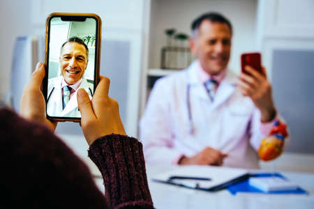 doctor and patient discussing something using smartphones in hospital