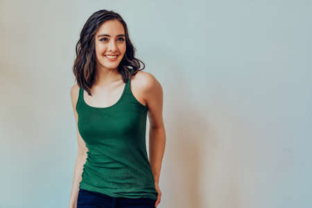 Woman with hand on pockets smiling looking to the sideの写真素材