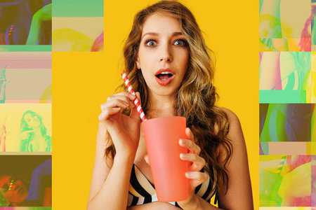 beautiful young woman holding cocktail on color background summertimeの写真素材