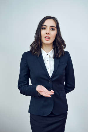 portrait of a beautiful young adult businesswoman manager wearing black jacket on a white background...