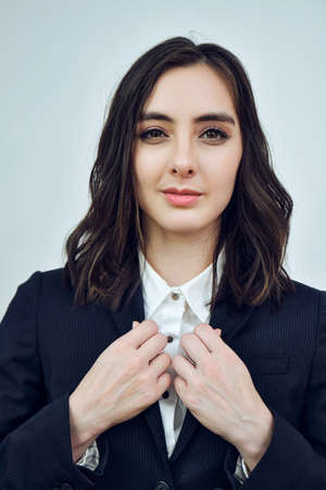 close up portrait of a young businesswoman wearing black jacket on a white background