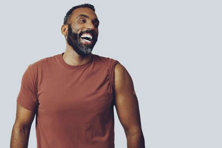 portrait mid adult bearded vaccinated man with plaster on arm laughing looking away at copy space