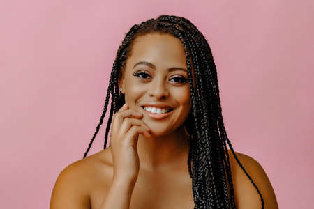 portrait of young adult thoughtful smiling beauty black woman with hand on chin braid hair looking...