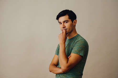 Portrait hispanic latino man with arms crossed hand on chin black hair thoughtful handsome young...