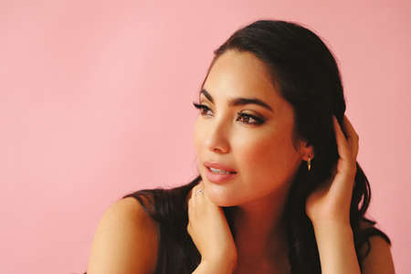 headshot of hispanic Latina woman smiling beauty young adult black long hair pattern pink dress in...