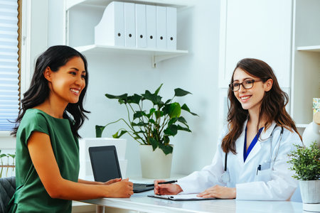Female doctor smiling with woman patient consultation clinic health checkupの写真素材