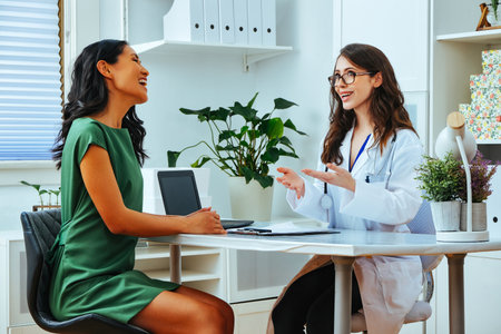 Female doctor smiling explaining treatment to happy woman patient consultation clinic health checkupの写真素材