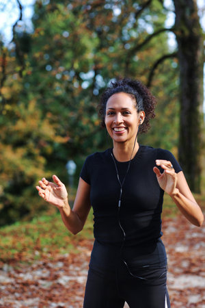 positive middle aged woman stretching outdoors preparing for exerciseの写真素材