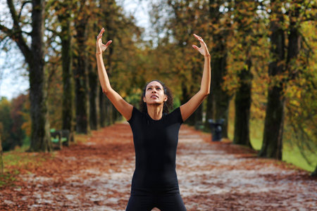 woman outdoors with arms open meditatingの写真素材