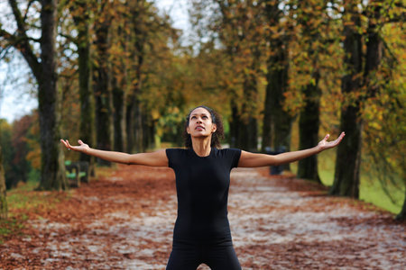 woman outdoors with arms open meditatingの写真素材