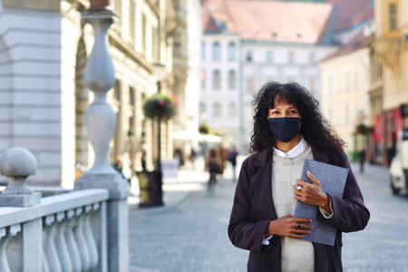 businesswoman standing in street with face maskの写真素材