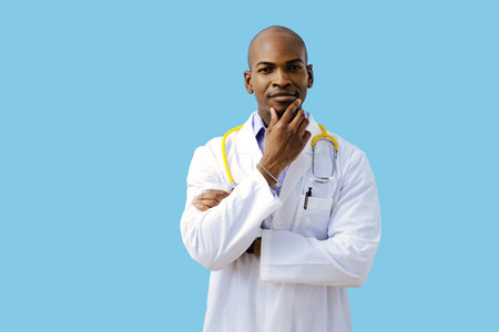 Thoughtful doctor with folded arms hand on chin wearing lab coatの写真素材