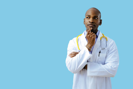 Thoughtful doctor with folded arms hand on chin wearing lab coatの写真素材