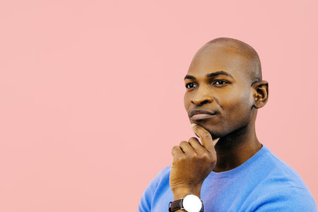profile thoughtful man with hand on chin looking at copy spaceの写真素材