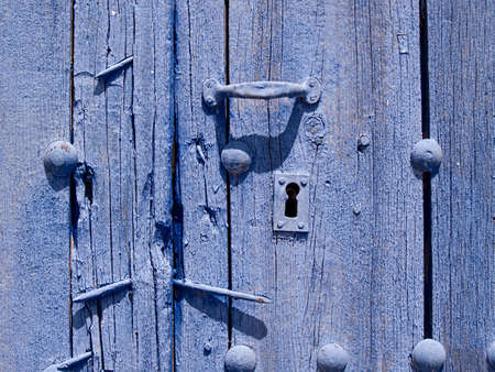 Detail of old door with keyhole painted in blue colorの写真素材