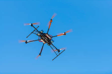 Professional drone flying over the airfield in hoverの写真素材