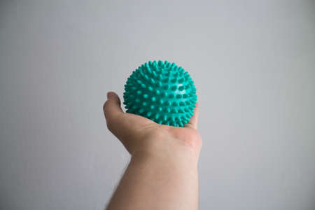 A man has a green massage ball in his left hand.の写真素材